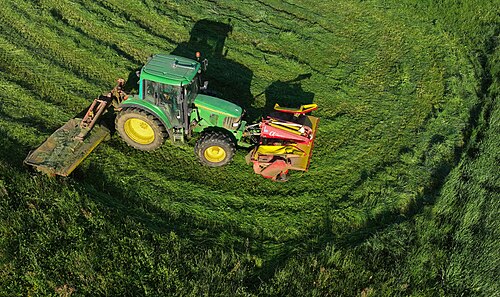 Tractor John Deere 6320 with front and rear mower cutting grass